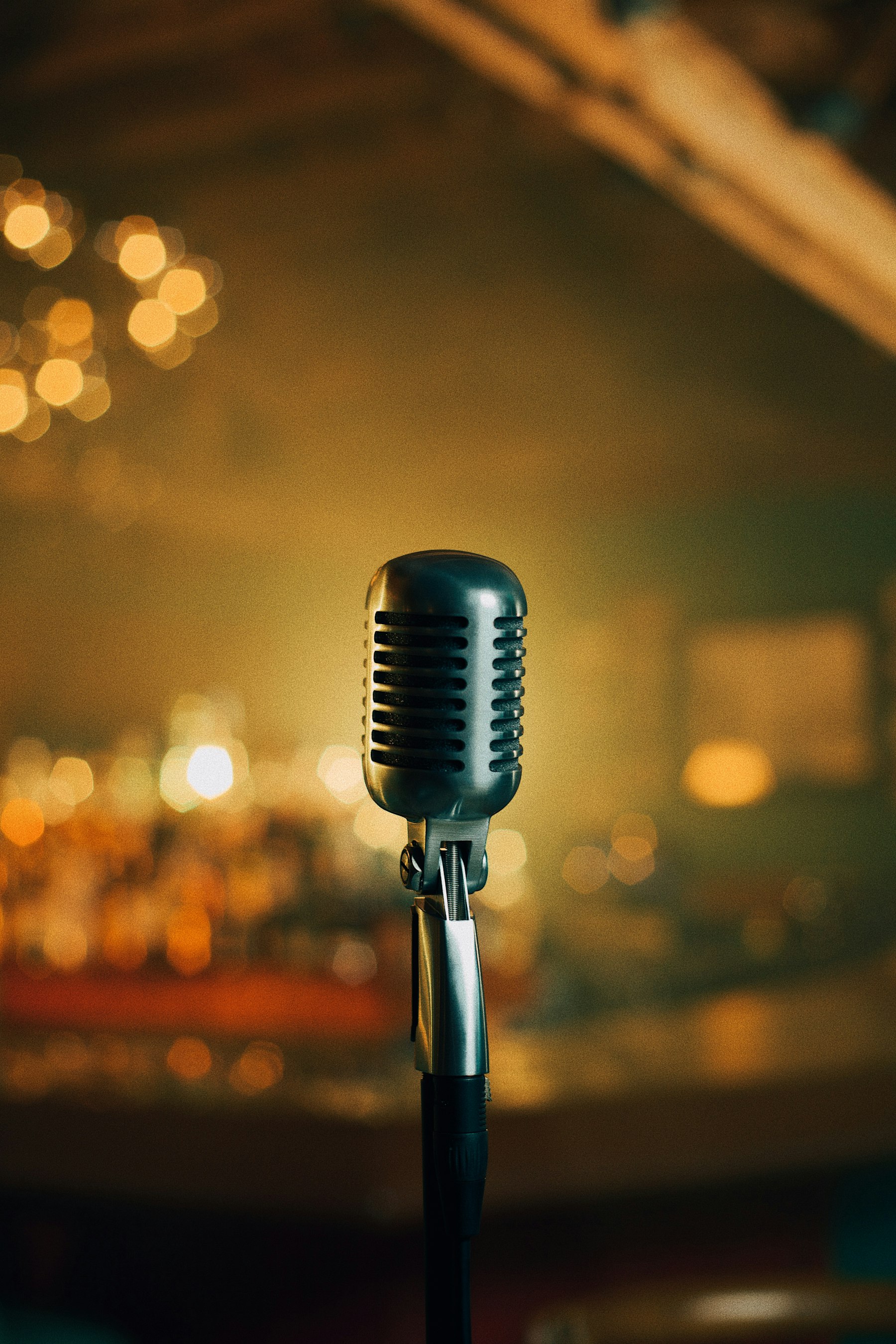 Vintage stage microphone against warm lights